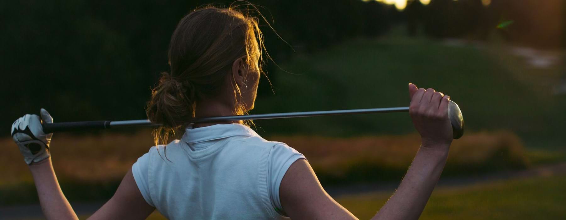a woman swinging a golf club